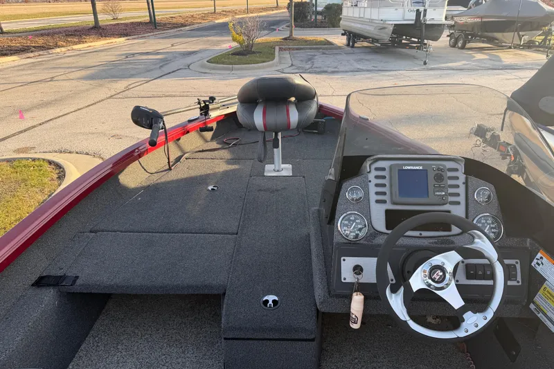 Slide: The Image of 2016 Ranger VS1680 boat interior with steering wheel and control panel in a parking lot. - 7