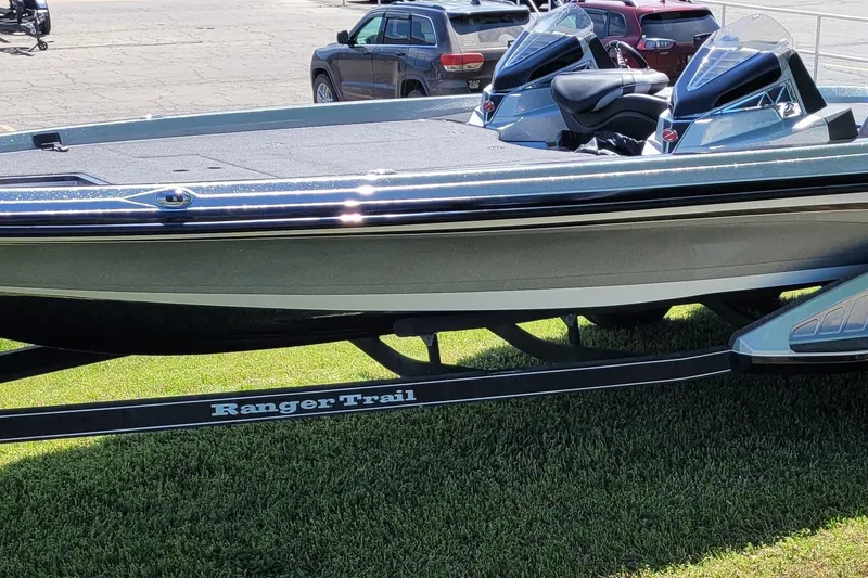 Slide: The Image of 2020 Ranger Z521L boat on trailer, parked on grass, with cars in background. - 3