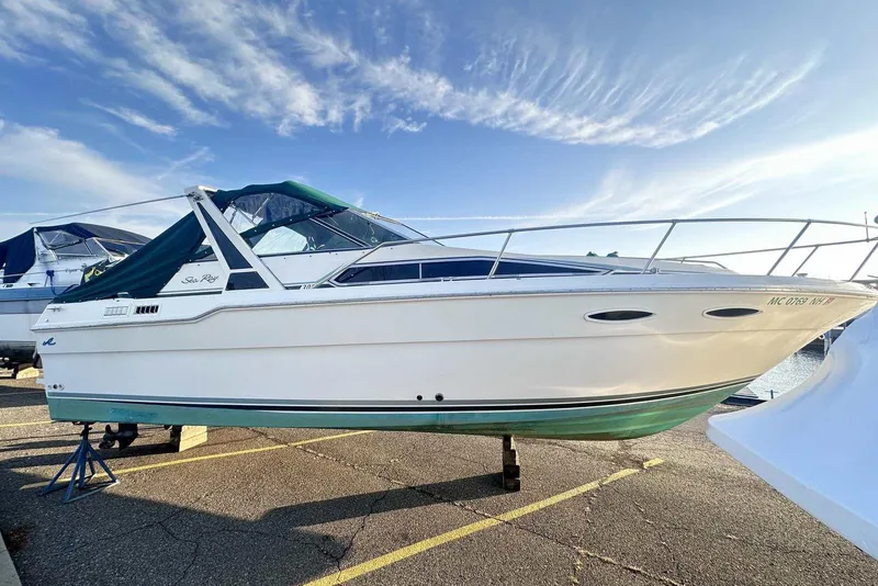 The Image of 1987 Sea Ray 300 Sundancer boat on a trailer under a clear blue sky. - 0