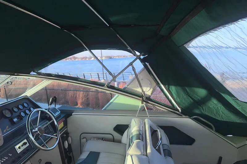 Slide: The Image of Interior view of a 1987 Sea Ray 300 Sundancer boat with green canopy and steering wheel. - 11