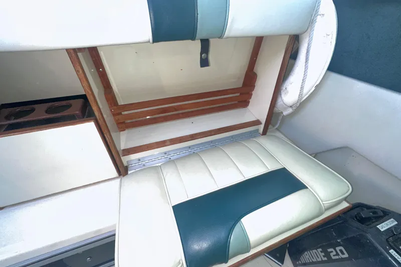 Slide: The Image of 1987 Sea Ray 300 Sundancer interior with white and teal seating and wooden accents. - 13