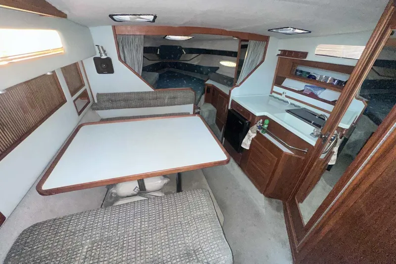 Slide: The Image of Interior of 1987 Sea Ray 300 Sundancer boat with dining area and kitchenette. - 19