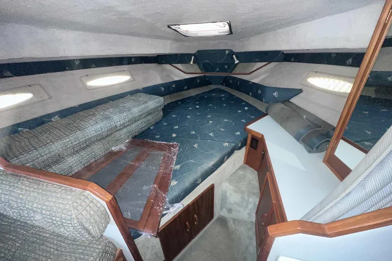 Slide: The Image of 1987 Sea Ray 300 Sundancer cabin interior with blue upholstery and wooden accents. - 25