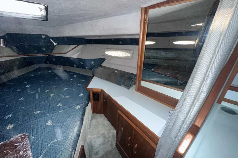 Slide: The Image of Interior cabin of 1987 Sea Ray 300 Sundancer with blue upholstery and wood accents. - 26