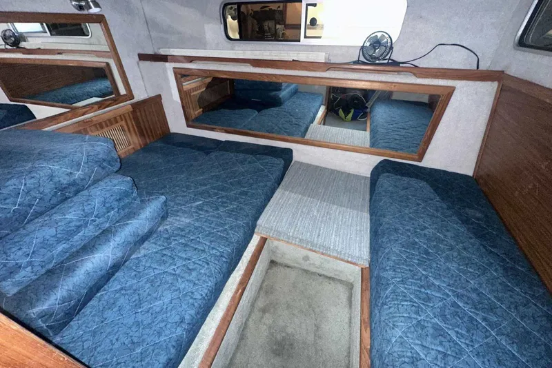 Slide: The Image of Interior cabin of 1987 Sea Ray 300 Sundancer with blue bedding and wood accents. - 27