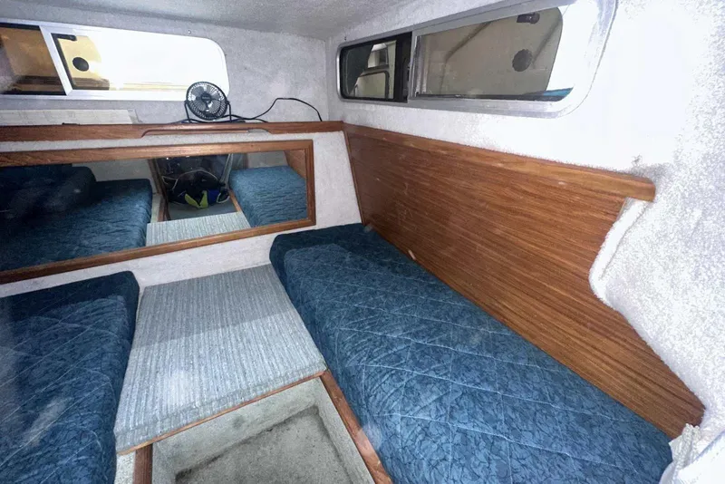 Slide: The Image of Interior cabin of 1987 Sea Ray 300 Sundancer with blue bedding and wood paneling. - 28