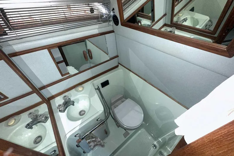 Slide: The Image of 1987 Sea Ray 300 Sundancer bathroom with sink, toilet, and mirrors. - 30