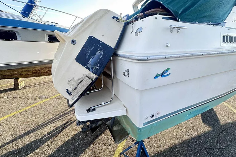 Slide: The Image of 1987 Sea Ray 300 Sundancer boat on dry dock, showing rear view and swim platform. - 6