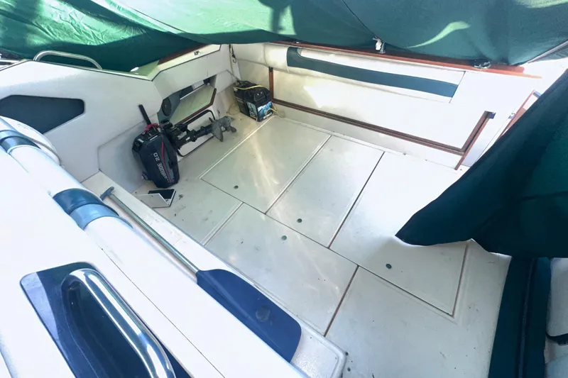 Slide: The Image of 1987 Sea Ray 300 Sundancer interior with green canopy, showing spacious deck and equipment. - 8