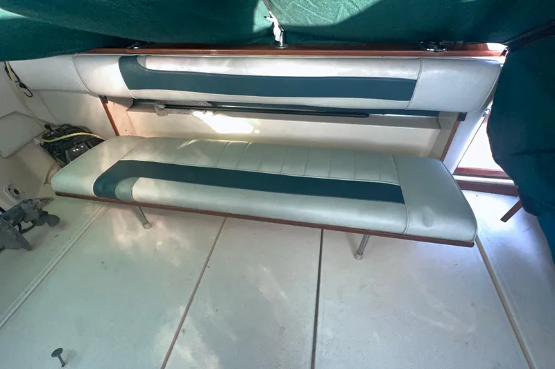 Slide: The Image of 1987 Sea Ray 300 Sundancer interior with cushioned seating and green accents. - 9