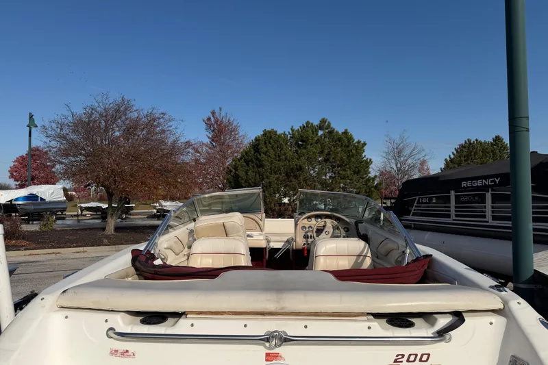 Slide: The Image of 1995 Sea Ray 200 Bow Rider boat with open seating, parked outdoors. - 4