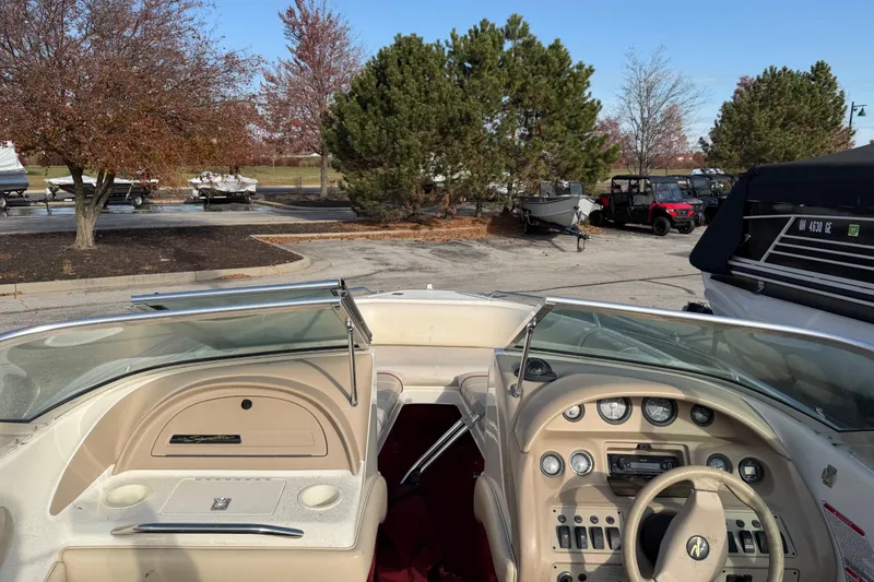 Slide: The Image of 1995 Sea Ray 200 Bow Rider dashboard and controls, parked outdoors with trees in background. - 5