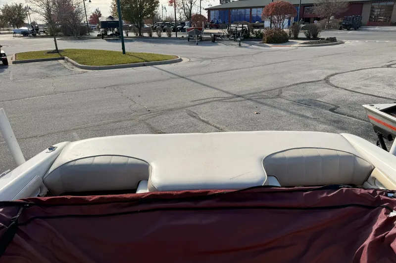 Slide: The Image of 1995 Sea Ray 200 Bow Rider boat interior with beige seating in a parking lot. - 6