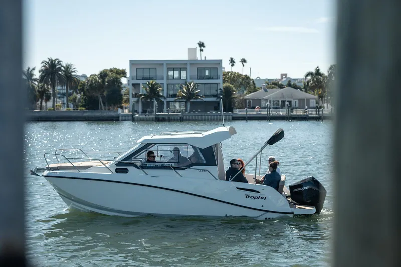 Slide: The Image of 2026 Bayliner Trophy T23 Explorer boat cruising near waterfront homes. - 7