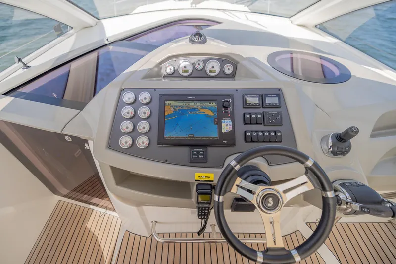 Slide: The Image of Cockpit of 2013 Beneteau Gran Turismo 38 with navigation controls and steering wheel. - 11