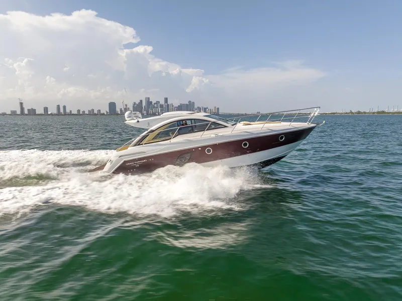 Slide: The Image of 2013 Beneteau GRAN TURISMO 38 cruising on water with city skyline in background. - 2