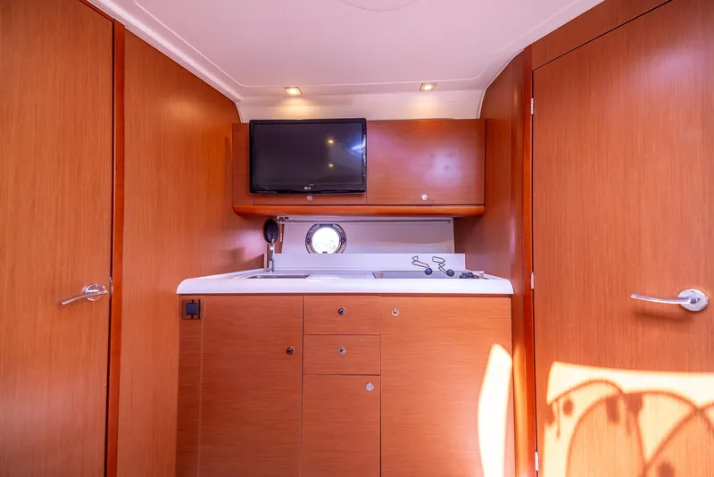 Slide: The Image of Interior of 2013 Beneteau Gran Turismo 38 yacht with wood cabinetry and mounted TV. - 26
