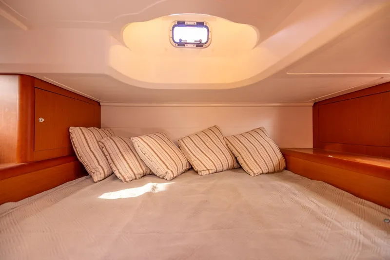 Slide: The Image of Cozy cabin interior of 2013 Beneteau Gran Turismo 38 with striped pillows and wooden accents. - 33