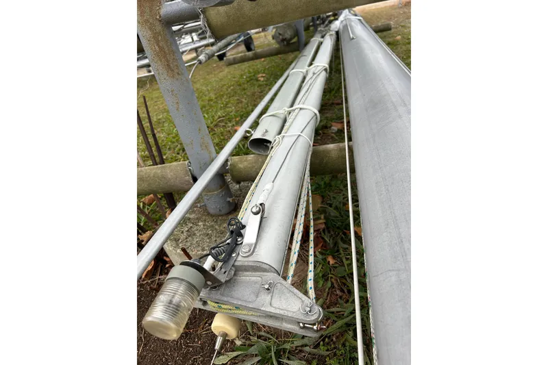 Slide: The Image of Close-up of a 1973 Willard 30 sailboat mast lying on grass. - 12