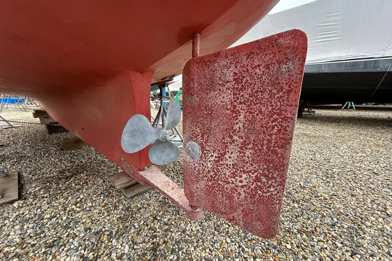 Slide: The Image of 1973 Willard 30 boat rudder and propeller on gravel surface. - 14