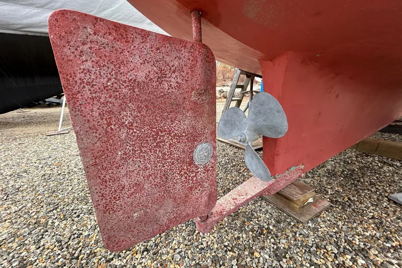 Slide: The Image of Rudder and propeller of a 1973 Willard 30 boat on gravel. - 15