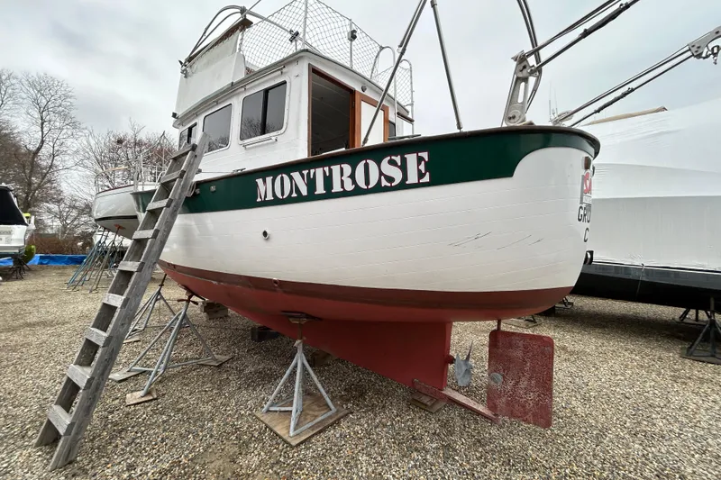Slide: The Image of 1973 Willard 30 boat "Montrose" on stands, with ladder, in a boatyard. - 2