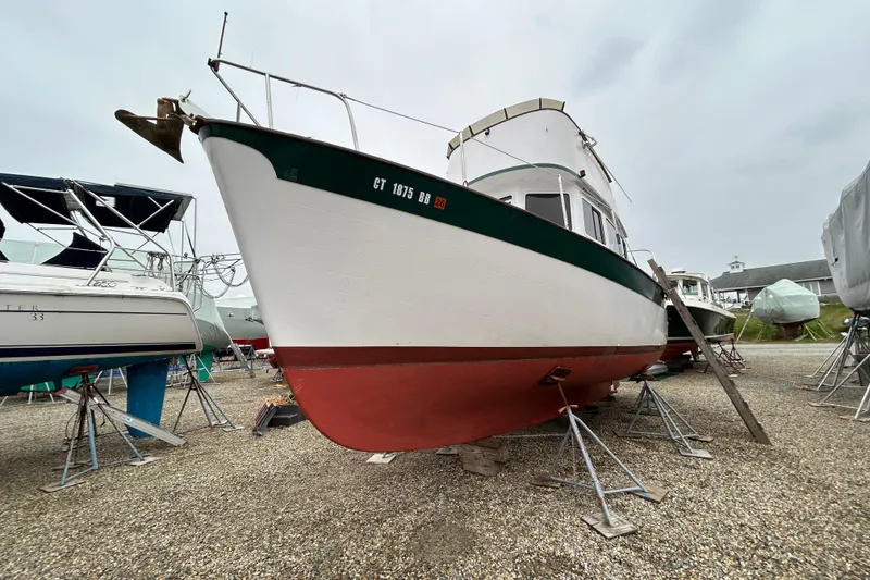 Slide: The Image of 1973 Willard 30 boat on stands in a boatyard, overcast sky. - 24