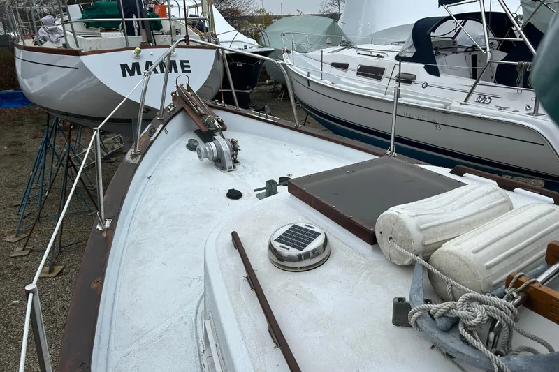Slide: The Image of 1973 Willard 30 boat on dry dock, surrounded by other sailboats, with visible deck equipment. - 28