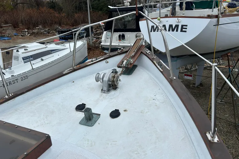 Slide: The Image of 1973 Willard 30 boat deck with anchor, surrounded by other docked boats. - 32