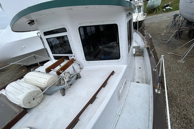 Slide: The Image of 1973 Willard 30 boat on land, featuring deck and cabin windows. - 36