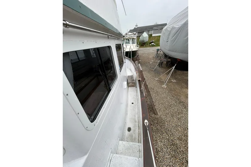Slide: The Image of 1973 Willard 30 boat on dry dock, side view with windows and covered vessels nearby. - 37