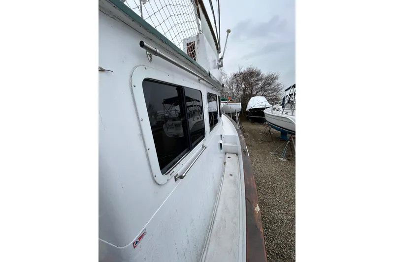 Slide: The Image of 1973 Willard 30 boat docked, side view with windows and overcast sky. - 40