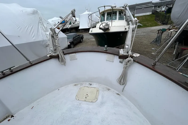 Slide: The Image of 1973 Willard 30 boat in storage yard, surrounded by covered vessels. - 42