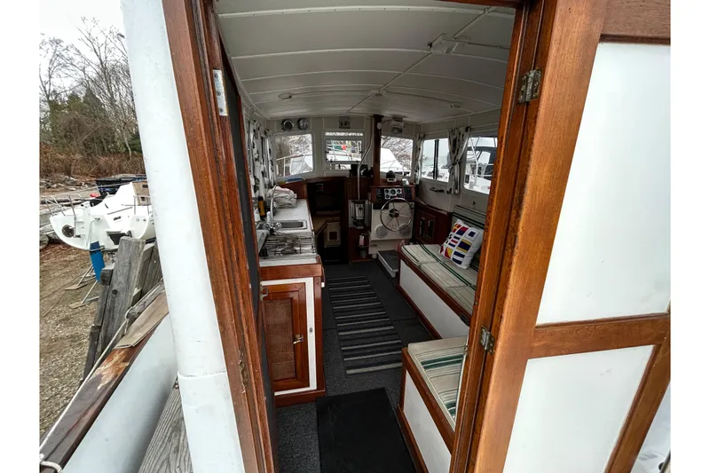 Slide: The Image of Interior view of a 1973 Willard 30 boat with wooden finishes and seating area. - 49