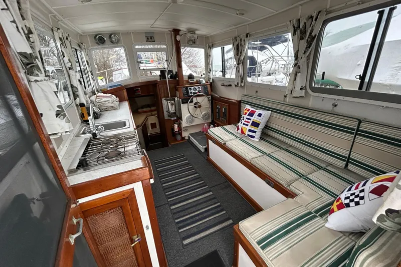 Slide: The Image of 1973 Willard 30 boat interior with striped seating, kitchenette, and nautical decor. - 50