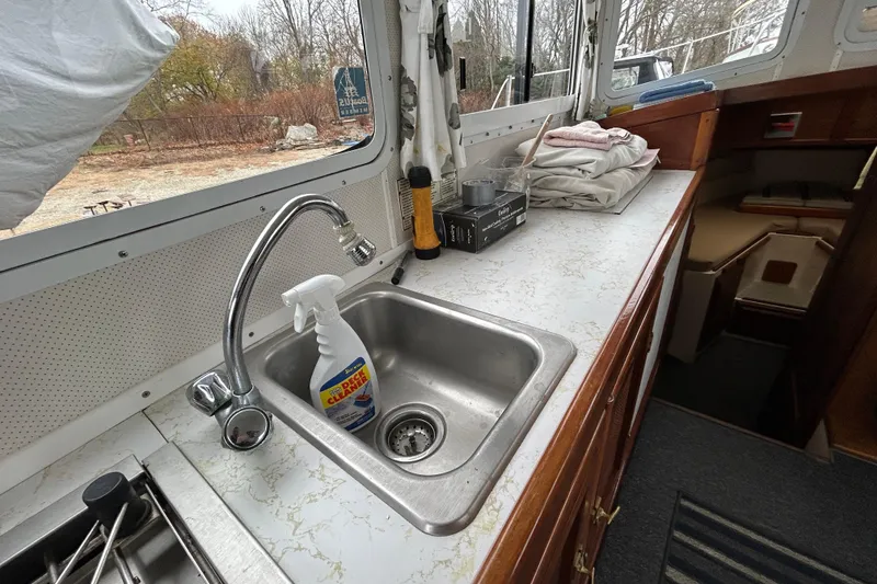 Slide: The Image of Interior of a 1973 Willard 30 boat with sink and cleaning supplies. - 54
