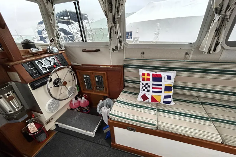Slide: The Image of 1973 Willard 30 boat interior with striped seating, nautical pillow, and control panel. - 60