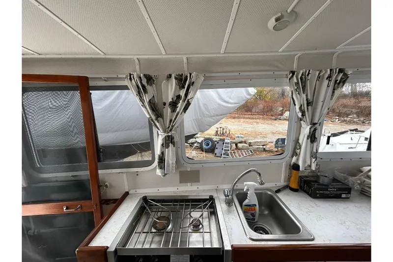 Slide: The Image of 1973 Willard 30 boat interior with kitchen sink, stove, and window view. - 68