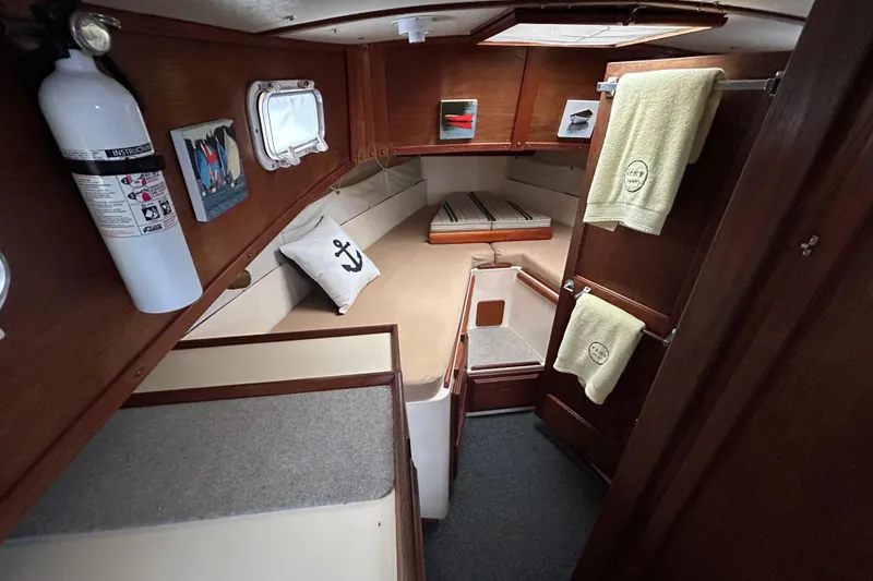 Slide: The Image of 1973 Willard 30 boat interior with cozy cabin, anchor pillow, and wooden accents. - 71