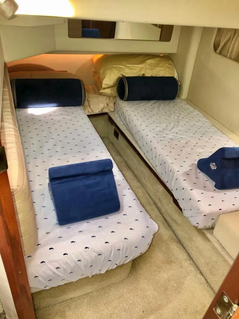 Slide: The Image of Twin beds in the 2006 Sea Ray 44 Sedan Bridge cabin, featuring blue and white bedding. - 24