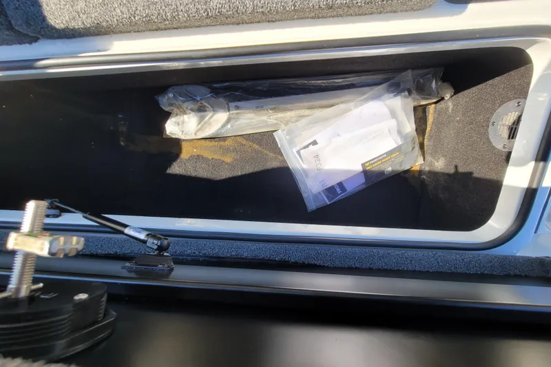 Slide: The Image of Storage compartment of 2024 Triton 179 TrX boat with documents and tools inside. - 11