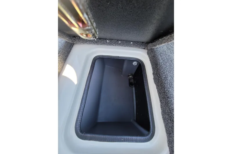 Slide: The Image of 2024 Triton 179 TrX storage compartment with carpeted interior and secure latch. - 12