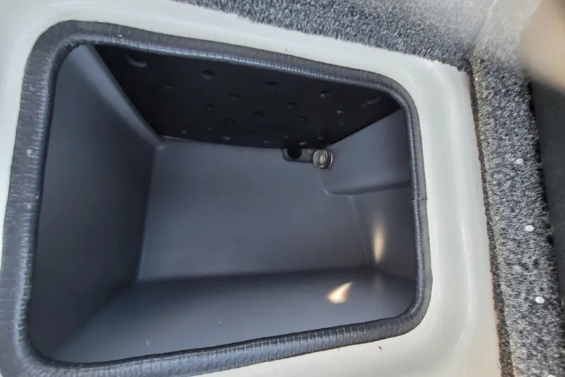 Slide: The Image of 2024 Triton 179 TrX boat storage compartment, gray interior, carpeted edges. - 13