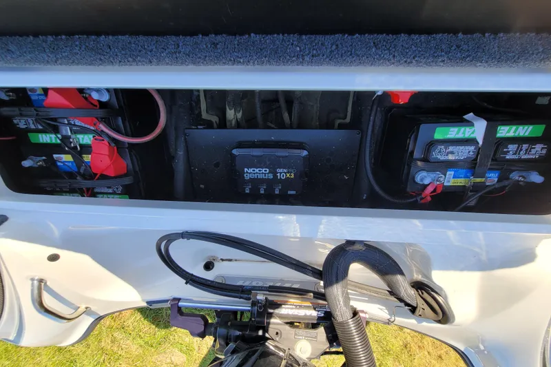 Slide: The Image of 2024 Triton 179 TrX boat battery compartment with NOCO Genius charger and Interstate batteries. - 16