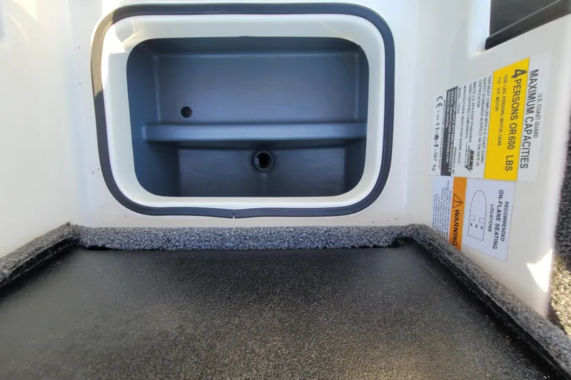 Slide: The Image of 2024 Triton 179 TrX boat storage compartment with capacity warning label. - 8
