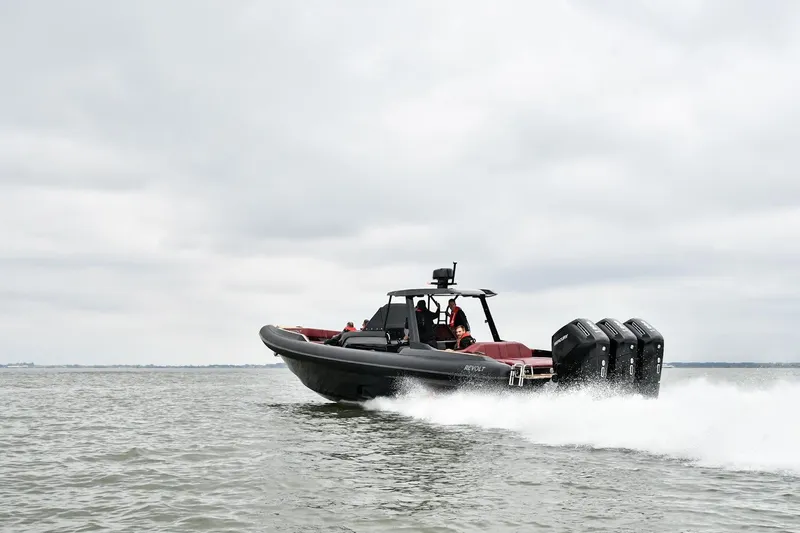 Slide: The Image of 2023 Revolt Comfort 47 boat speeding on water under cloudy sky. - 1