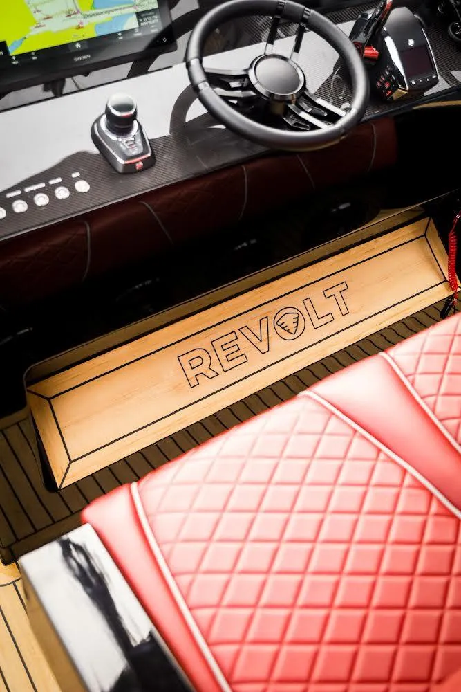 Slide: The Image of 2023 Revolt Comfort 47 interior with red quilted seating and modern steering controls. - 11