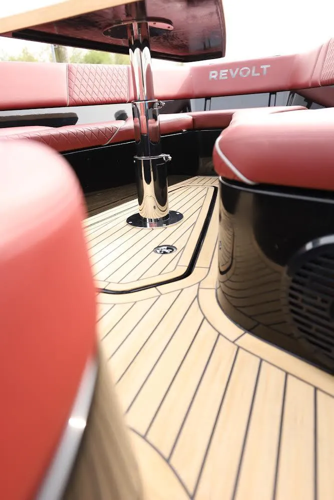 Slide: The Image of 2023 Revolt Comfort 47 boat interior with red seating and sleek wooden flooring. - 17