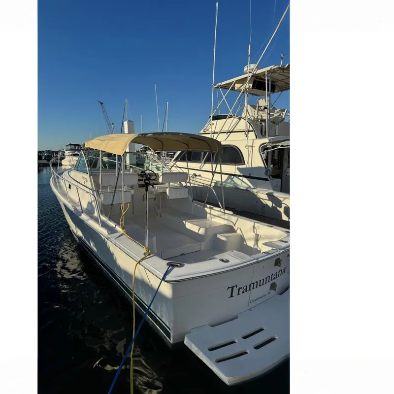 The Image of 2000 Mainship Pilot 30 boat docked at marina under cloudy sky. - 0