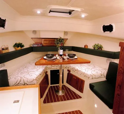 Slide: The Image of 2000 Mainship Pilot 30 docked at marina under cloudy sky. - 12